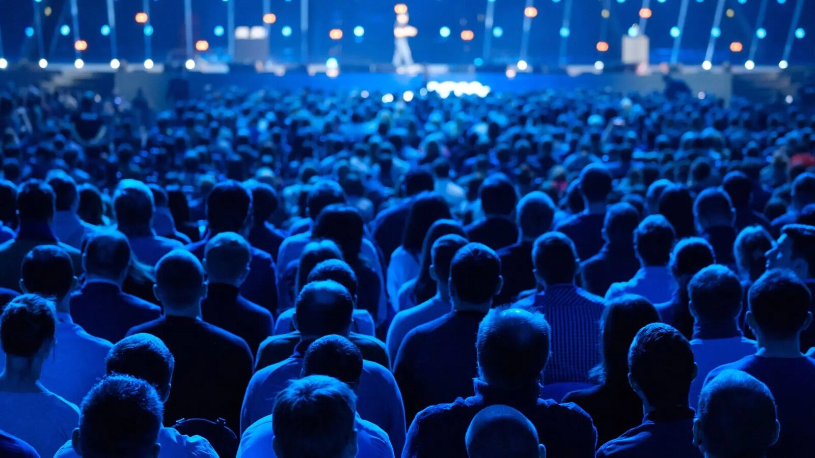 Large audience at a keynote event lit in blue